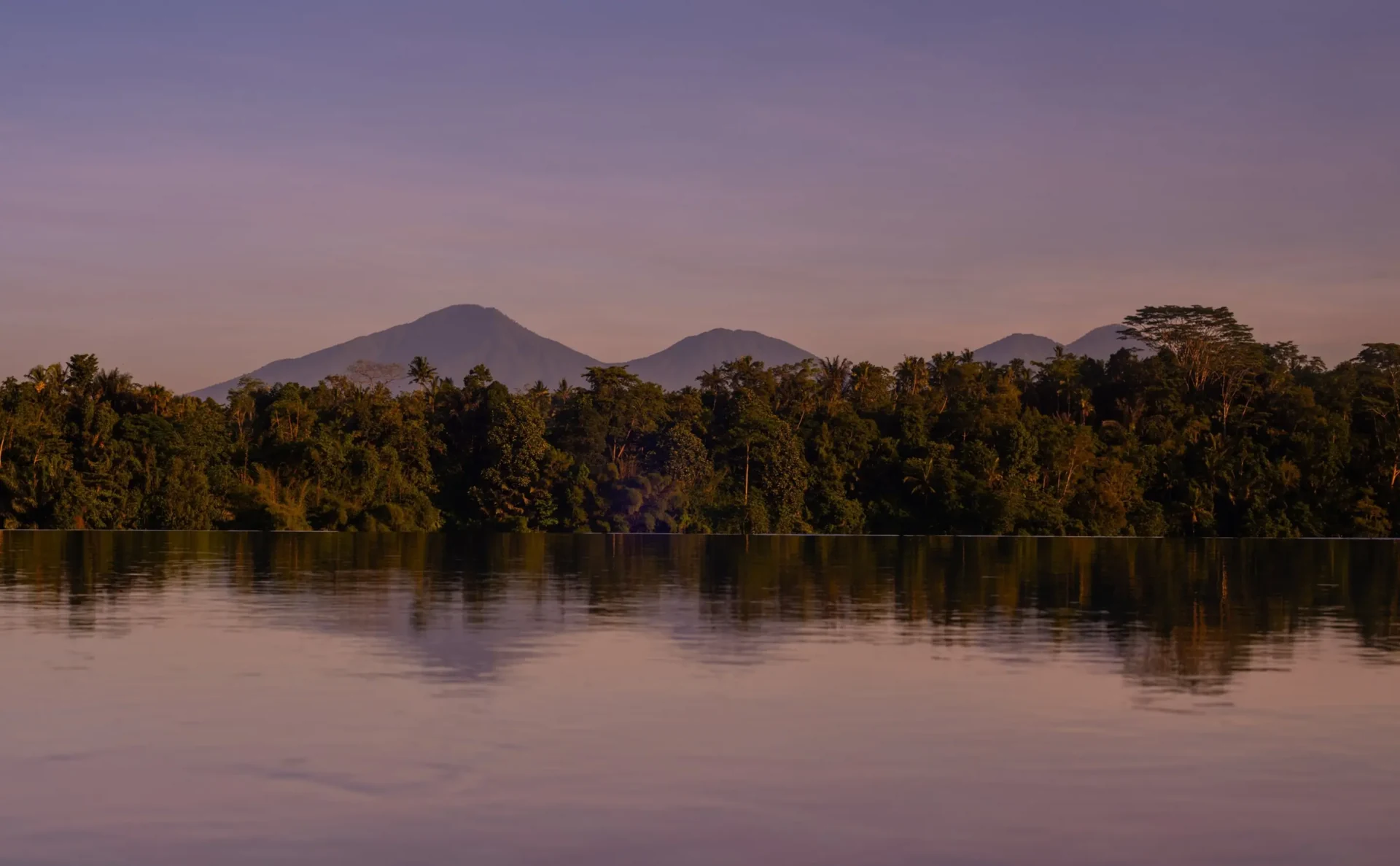 The infinity pool at Amandari, Ubud, with the green valley and Mount Agung at dusk