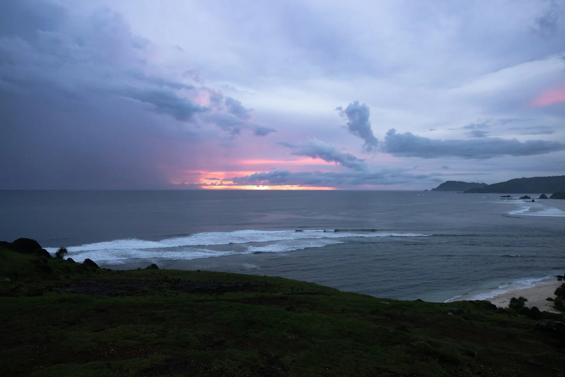 Evening surf along Tanjung Aan beneath a purple sunset sky