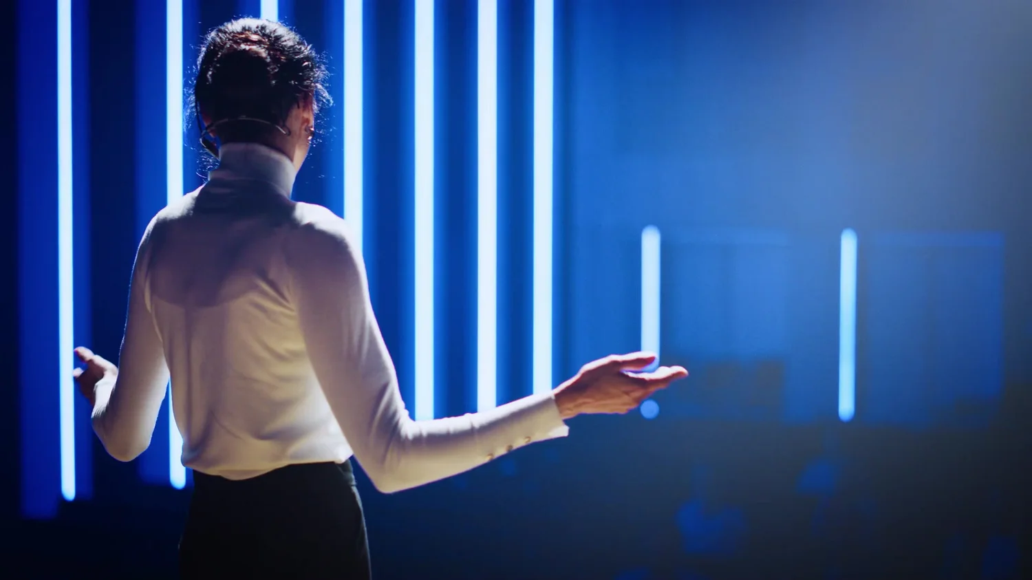 DJ performing against blue stage lighting