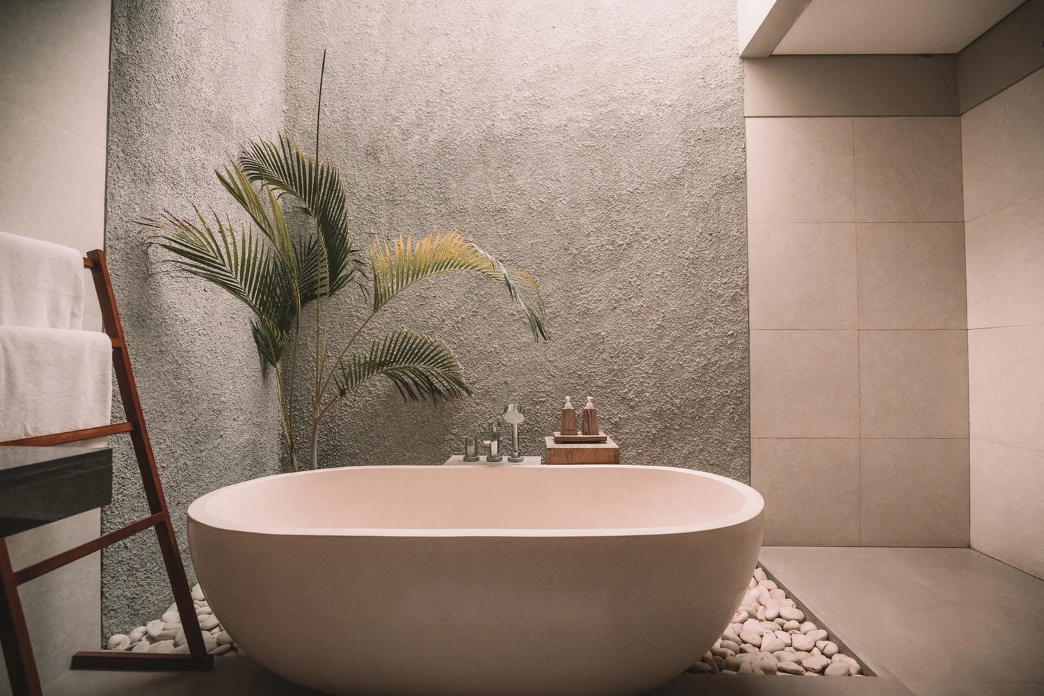 A freestanding bath and warm stone finishes in a quiet spa interior
