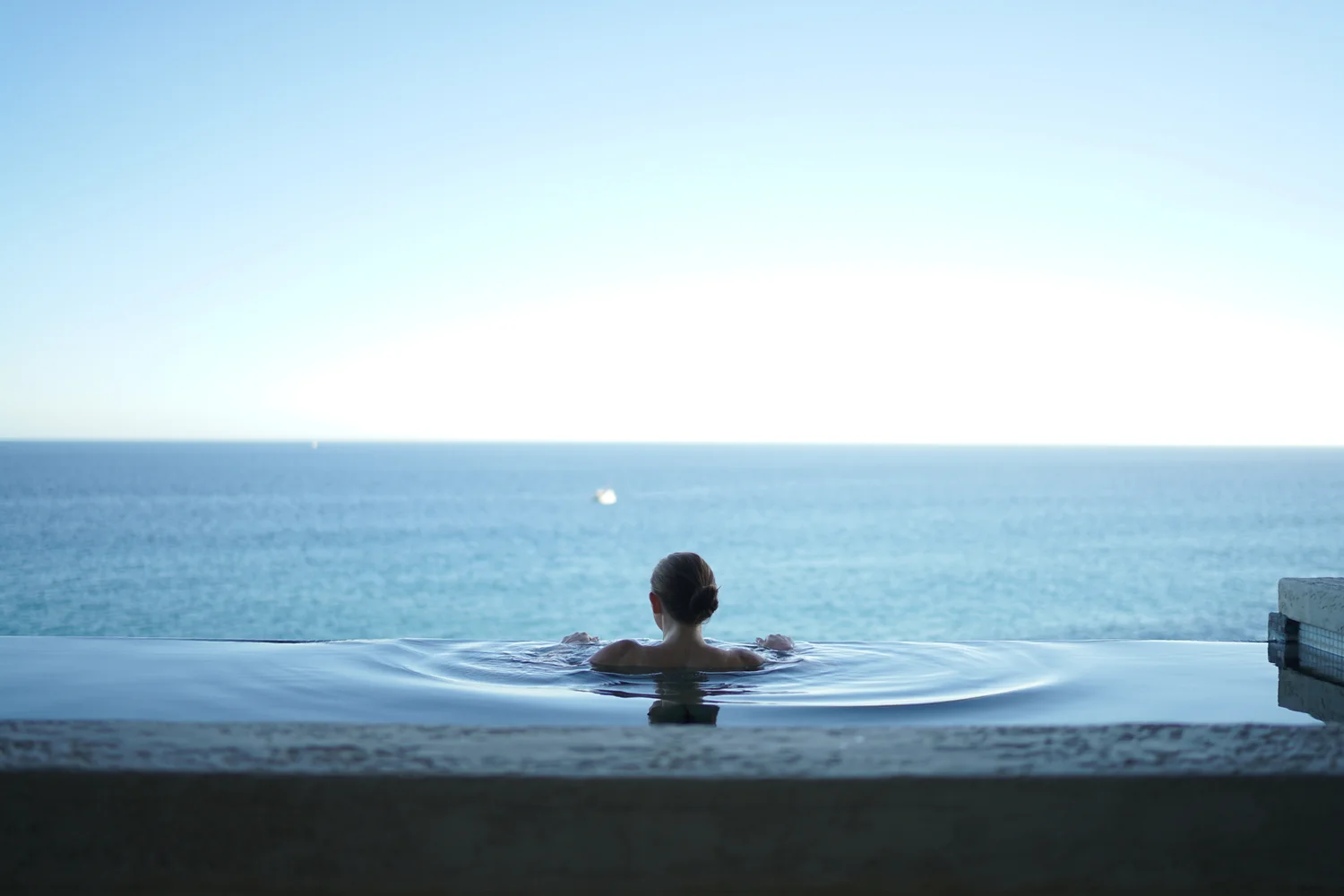 Guest enjoying an ocean-view infinity pool