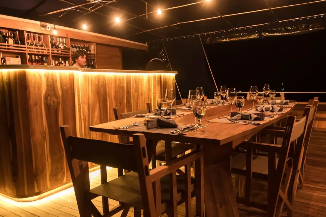 A candlelit private dining table in a warm wood-lined interior